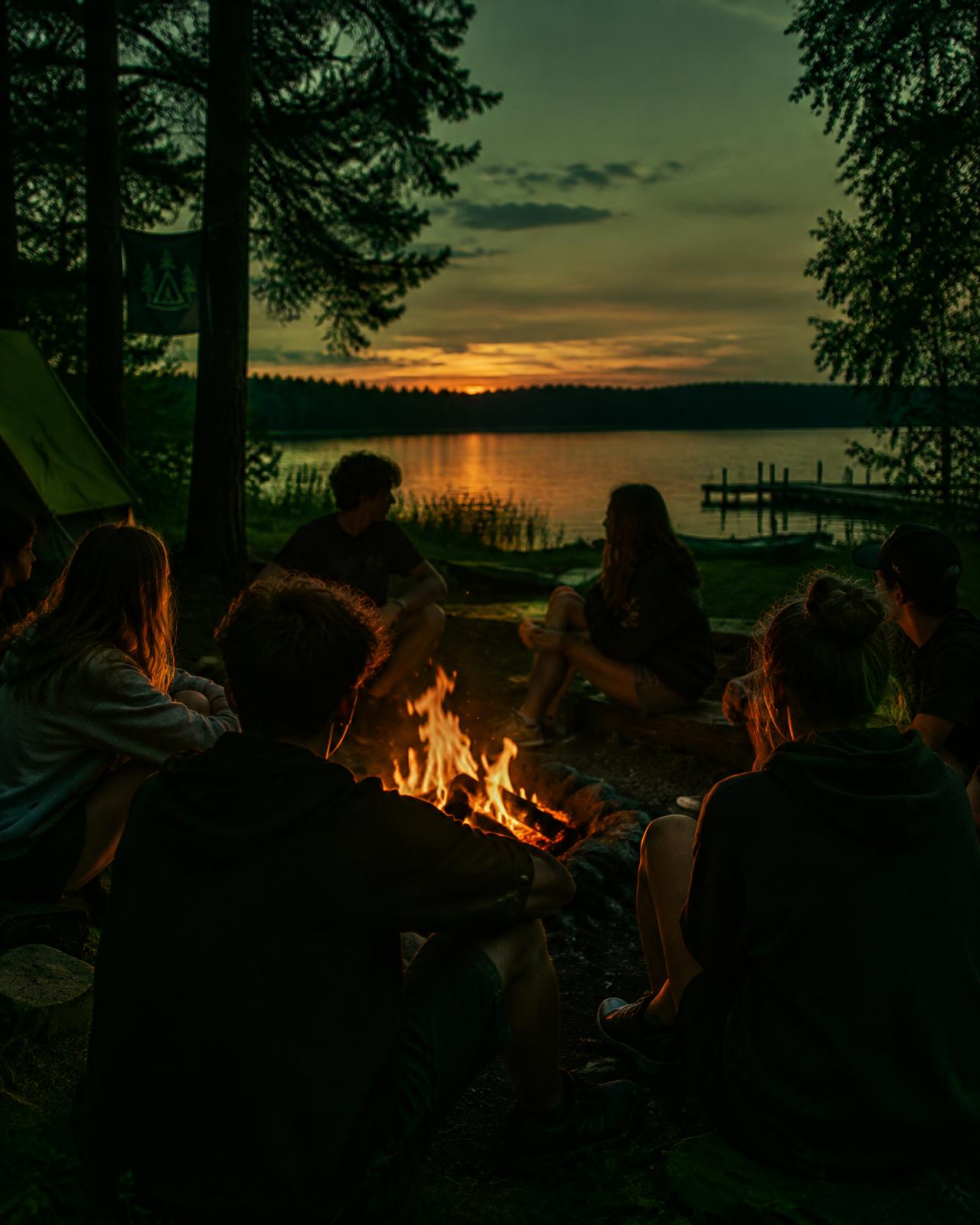 Jugendliche am Lagerfeuer bei einer Ferienfreizeit